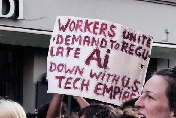 Demoschild "Workers unite. Demand to regulate AI. Down with U.S. tech empire.