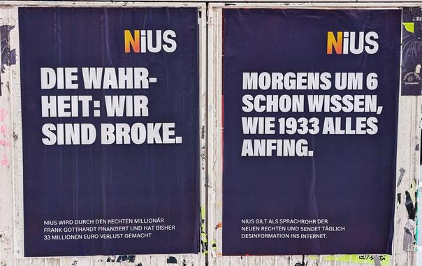 Zwei geklebte Plakate mit weißem Text auf dunkel violettem Hintergrund, dazu das Logo von Nius.

Text links: "Die Wahrheit: Wir sind broke"
Text rechts: "Morgens um 6 schon wissen, wie 1933 alles anfing"

Unten jeweils Kleingedrucktes